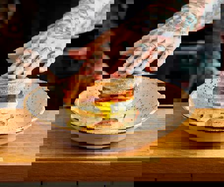 Our signature Sausage breakfast muffin. Sausage patty, melted cheese, runny fried egg and homemade hash browns