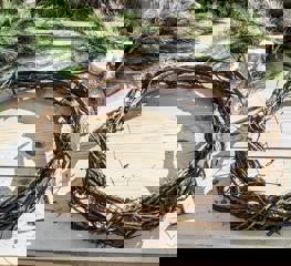 An outline of a wreath made of wood sits upon a table, ready to be adorned