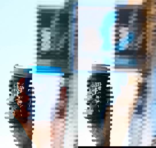 A hand holding a blue reusable coffee cup with the words 'Be an everyday hero' in white written across it